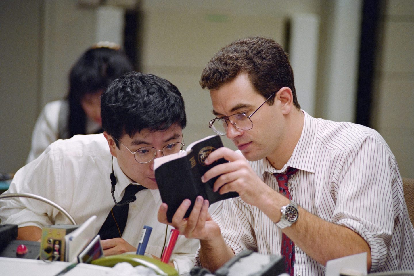 A foreign trader shows his Japanese colleague an english dictionary