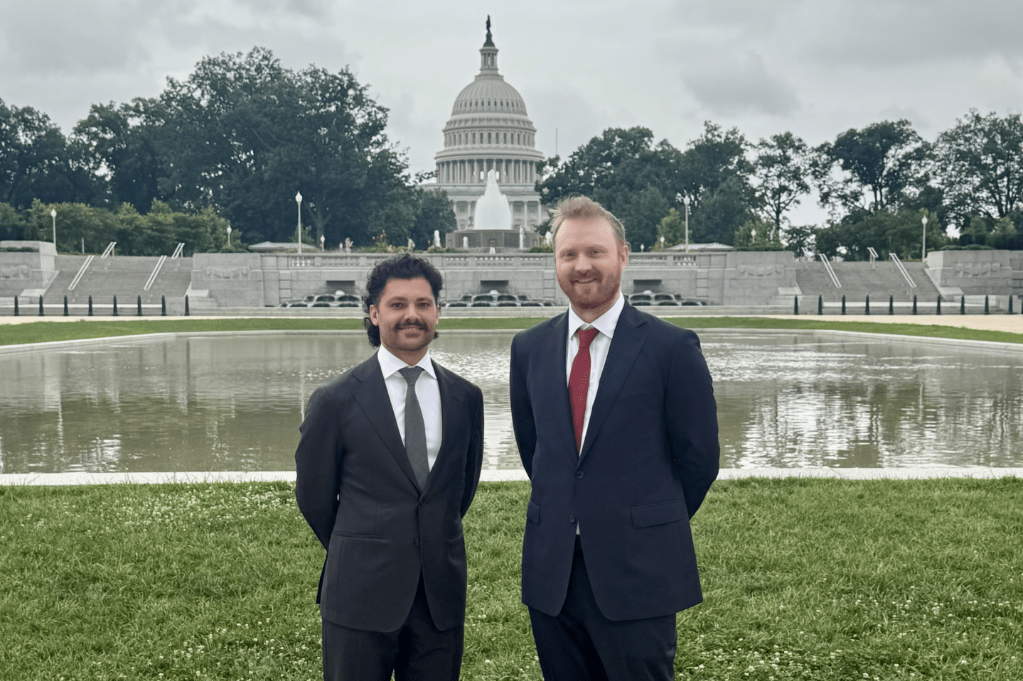 An image of Fabrizio Giabardo and Matt O'Connor in suits standing in front of the U.S. Capitol.