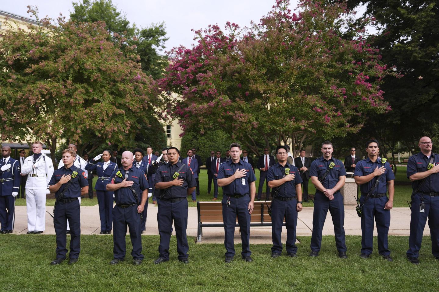 Armed Forces and first responders stand in a formation and have their hands over their hearts in remembrance of the 9/11 attacks.