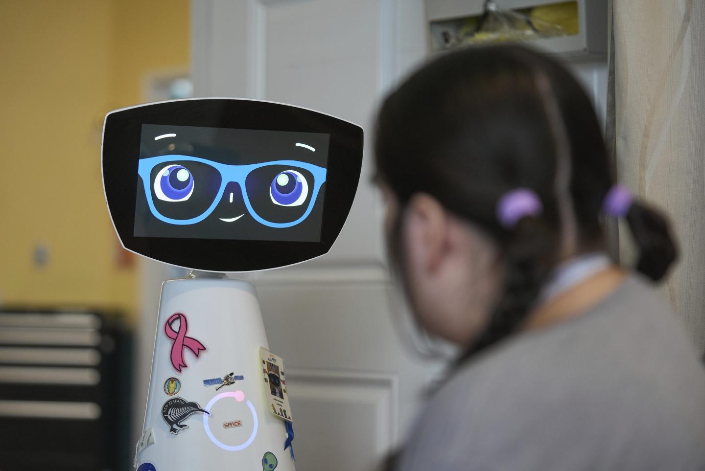 A therapy robot named Robin talks to a child in a hospital