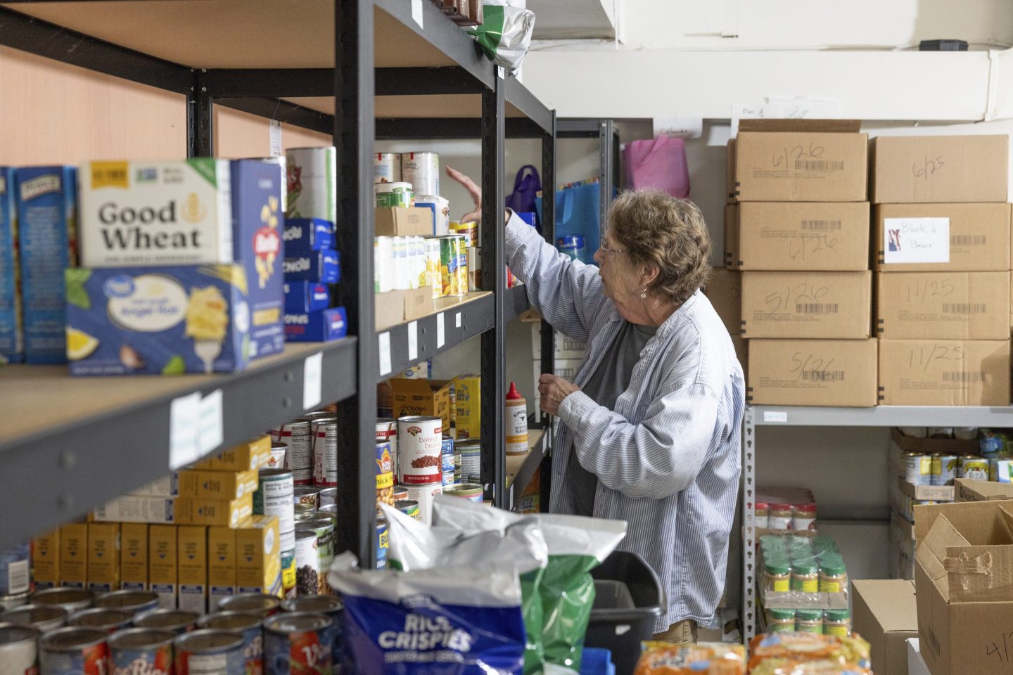 Phylis Allen organizes supplies at Neighbor's Cupboard in Winterport, Maine, a food pantry that she has helped run for the past 17 years.