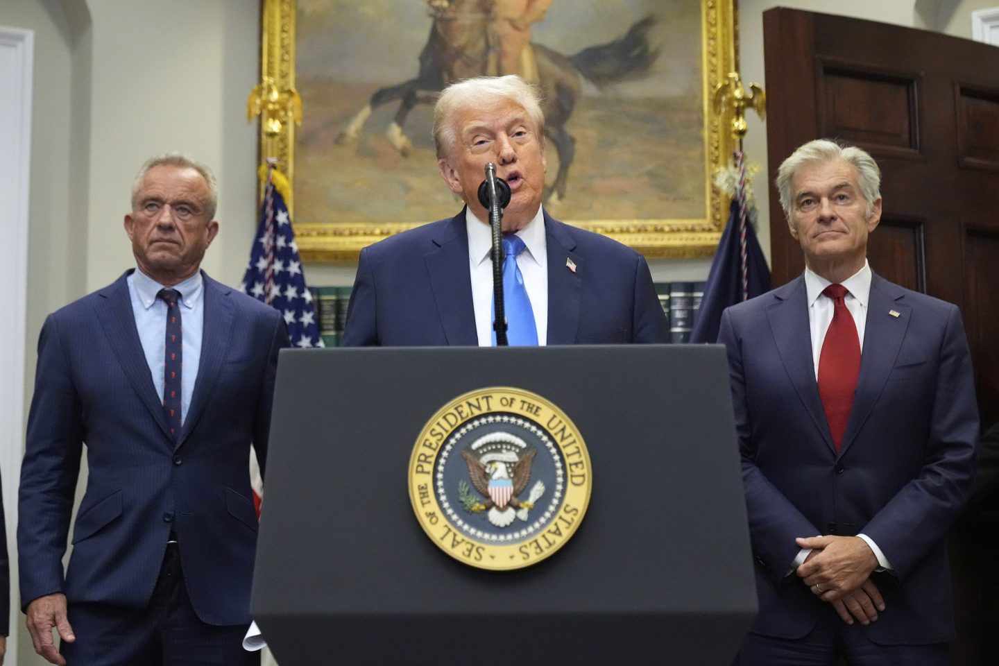 President Donald Trump speaks in the Roosevelt Room of the White House, Monday, Sept. 22, 2025, in Washington, as Health and Human Services Secretary Robert F. Kennedy Jr., left, and Centers for Medicare and Medicaid Services administrator Dr. Mehmet Oz listen.