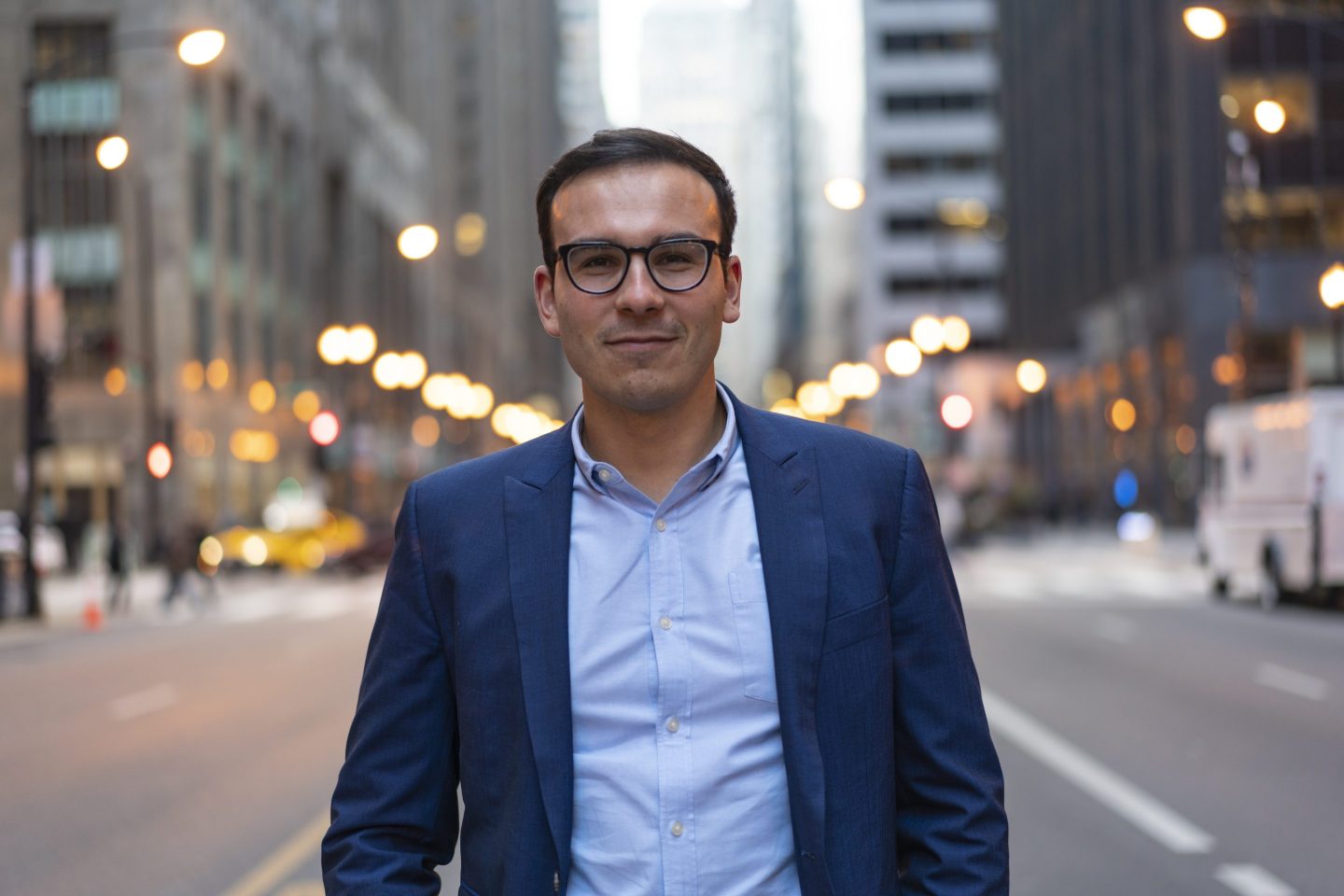 Edward Woodford starting at the camera in the middle of a busy street.