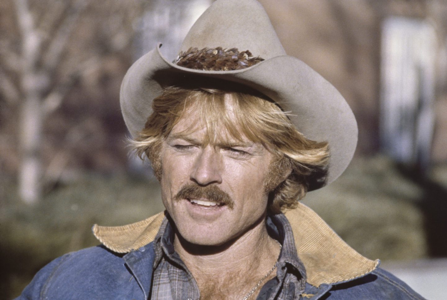 Young Robert Redford wearing a cowboy hat and a mustache