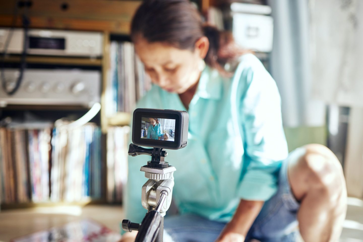 An older woman records videos on a tripod.