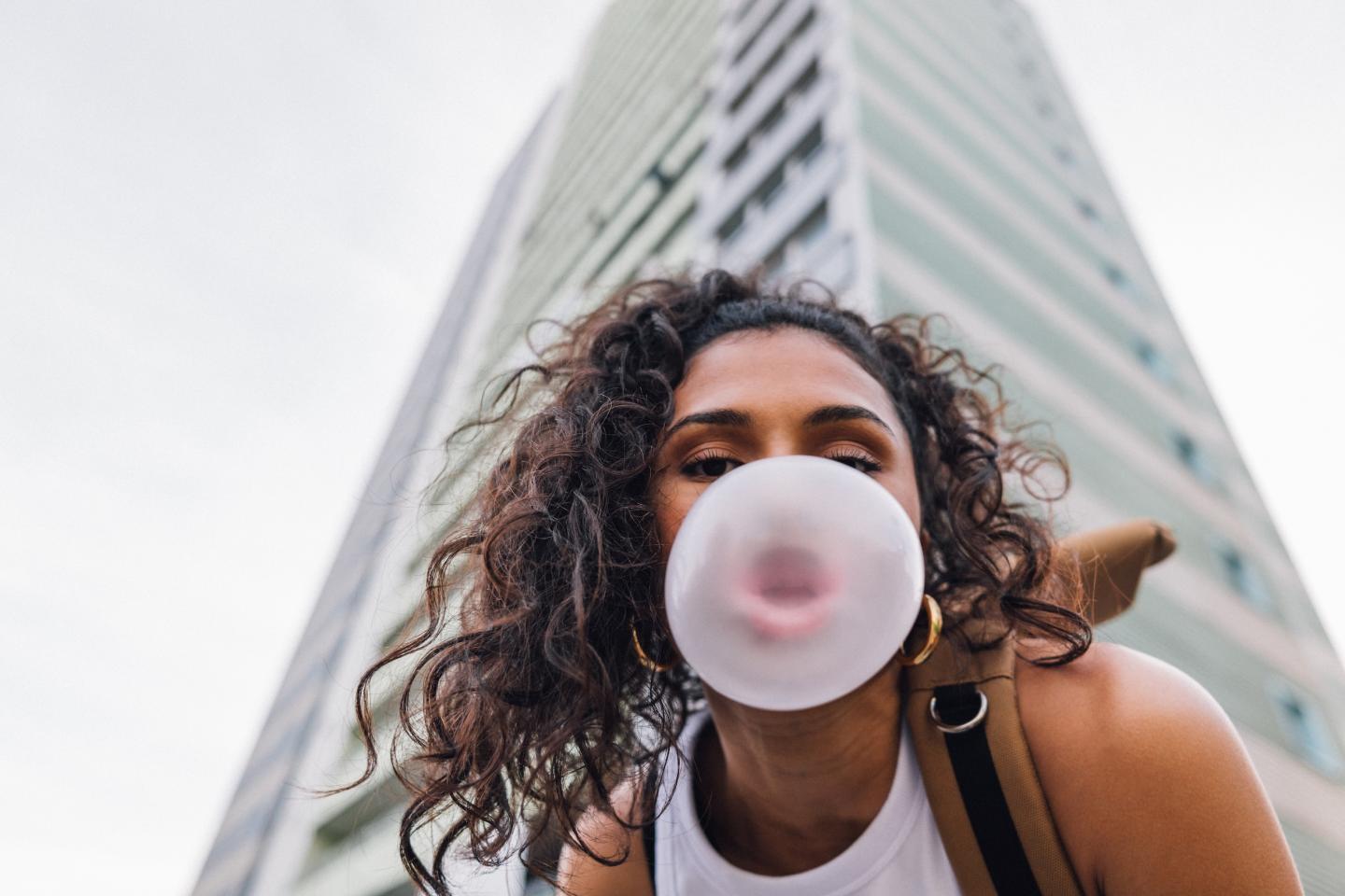 Photo: Young woman spending day outside in residential area in city.