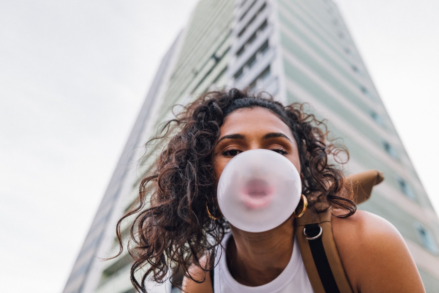 Photo: Young woman spending day outside in residential area in city.