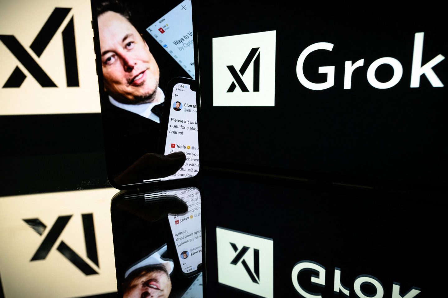 Screens displaying the logo of Grok, a generative artificial intelligence chatbot developed by xAI, the American company specializing in artificial intelligence and it's founder Elon Musk.