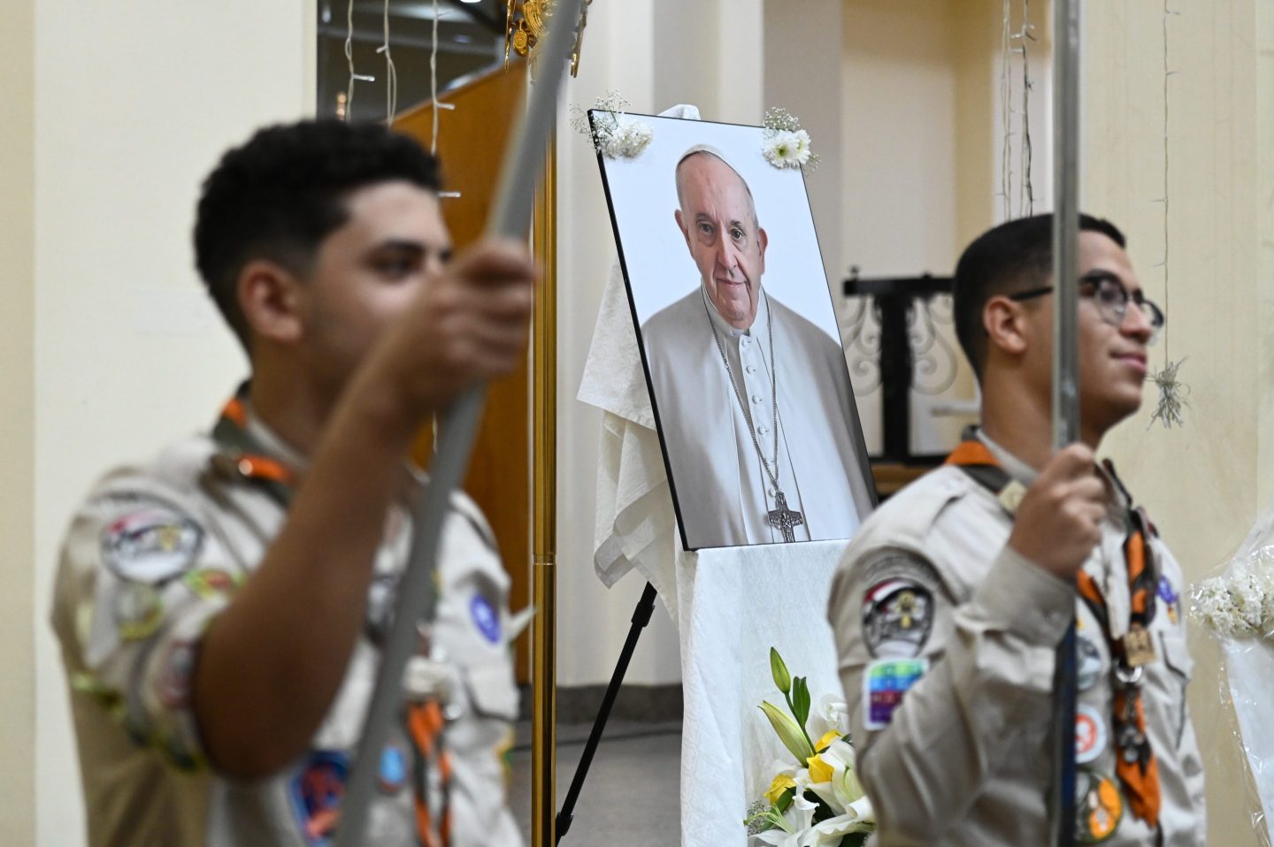 Egyptian boy scouts attend a service, with the late Pope Francis' photo in the background, for the late Pope at the Holy Virgin Mary Coptic Catholic Cathedral on April 22, 2025 in Cairo, Egypt.