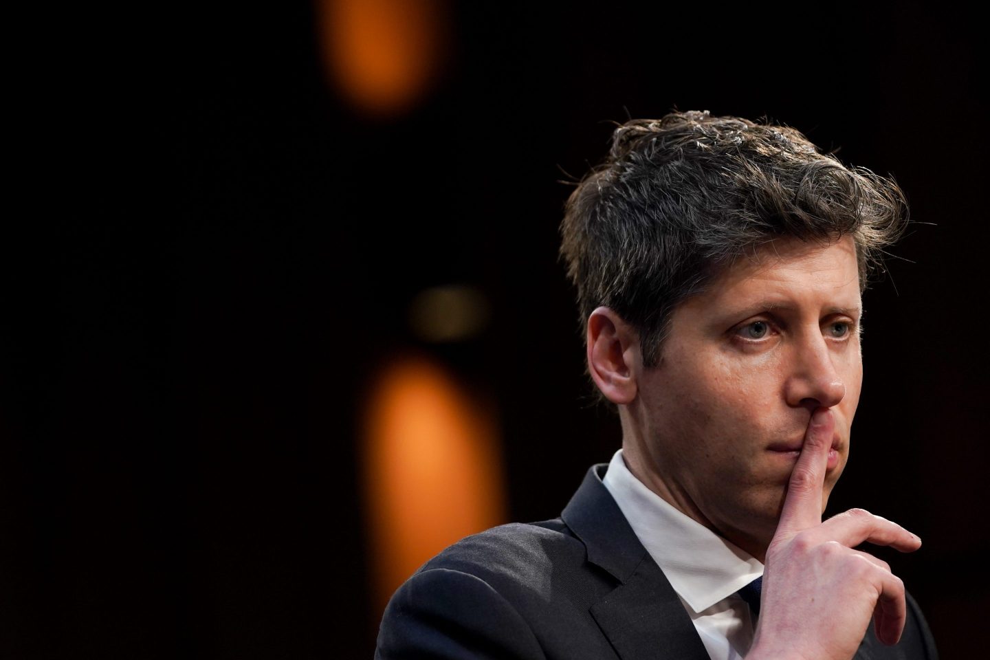 Sam Altman puts his finger to his lips in contemplation during a Senate Commerce, Science, and Transportation Committee hearing in Washington, DC, US, on Thursday, May 8, 2025.