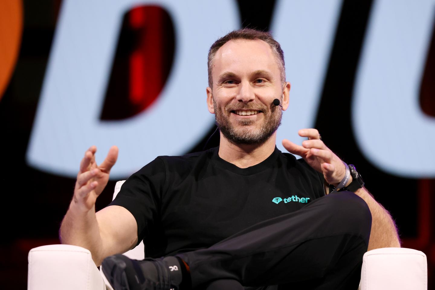 Paolo Ardoino speaks on stage at a Bitcoin conference.