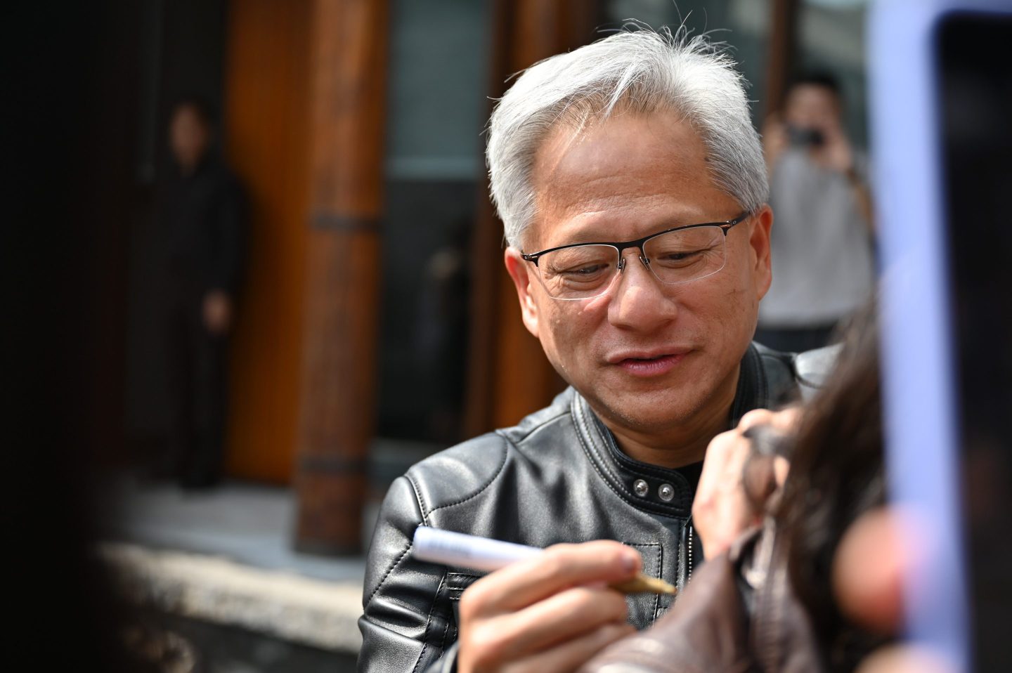 Jensen Huang signs with a marker.