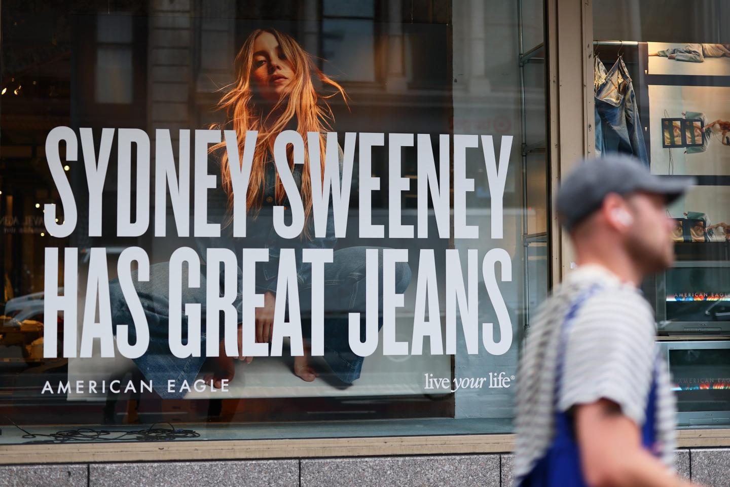 A man walks by a window display of actress Sydney Sweeney on a window of an American Eagle store on August 01, 2025 in New York City.