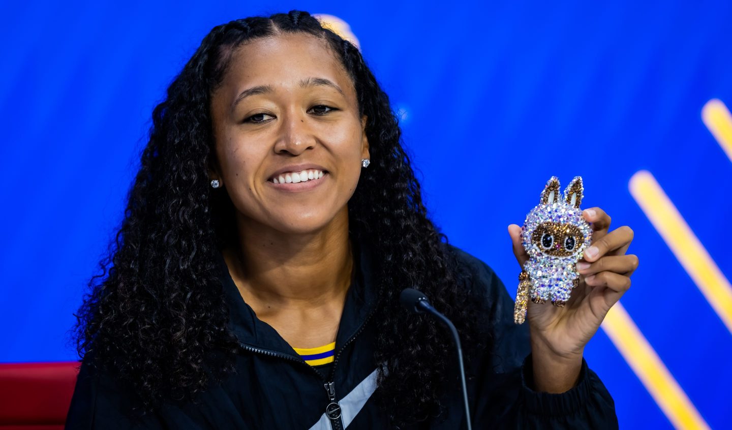 Naomi Osaka of Japan shows off her grey sparkling Labubu Althea Glitterson while talking to the media after defeating Coco Gauff of the United States in the fourth round on Day 9 of the US Open at USTA Billie Jean King National Tennis Center on September 01, 2025 in New York City.