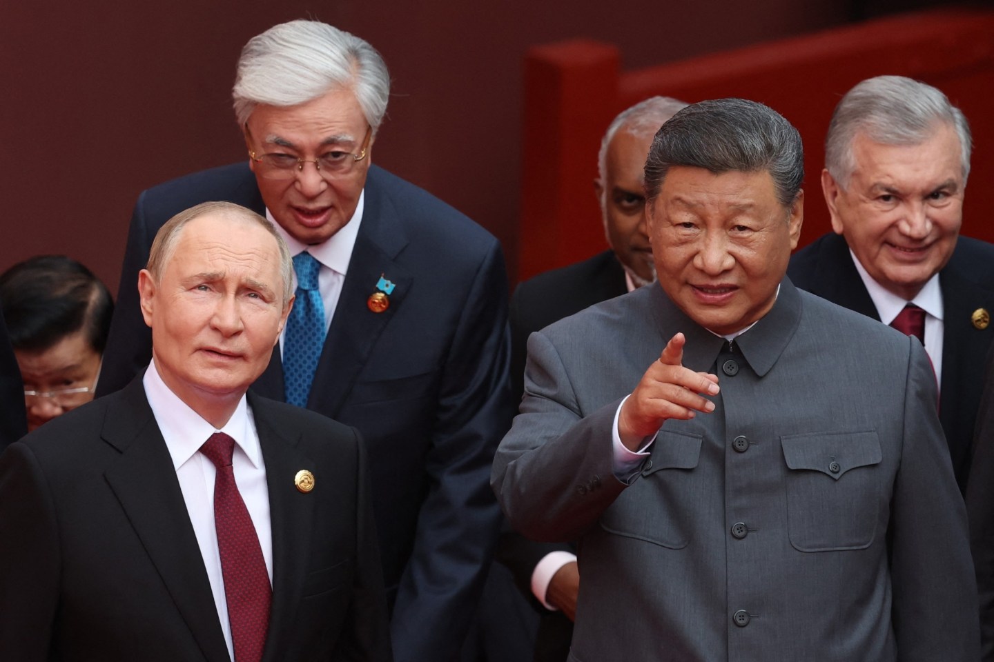 In this pool photograph distributed by the Russian state agency Sputnik, Russia's President Vladimir Putin (L) speaks with China's President Xi Jinping after a group photograph before a military parade marking the 80th anniversary of victory over Japan and the end of World War II, in Beijing's Tiananmen Square on September 3, 2025.