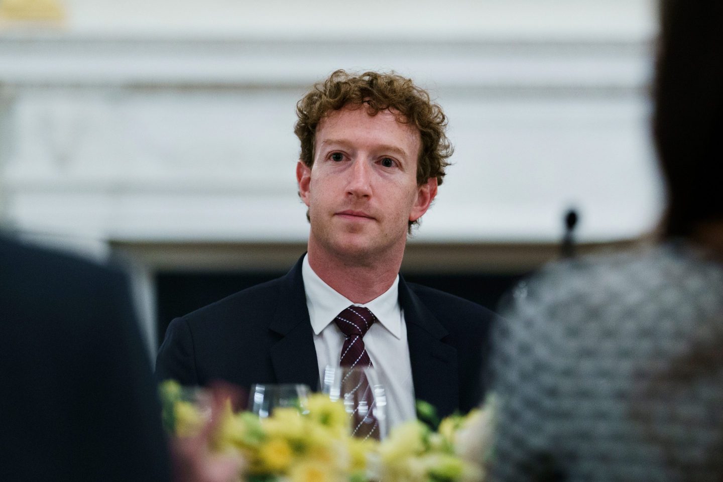 Mark Zuckerberg, wearing a suit, looks stoically out in front of him.
