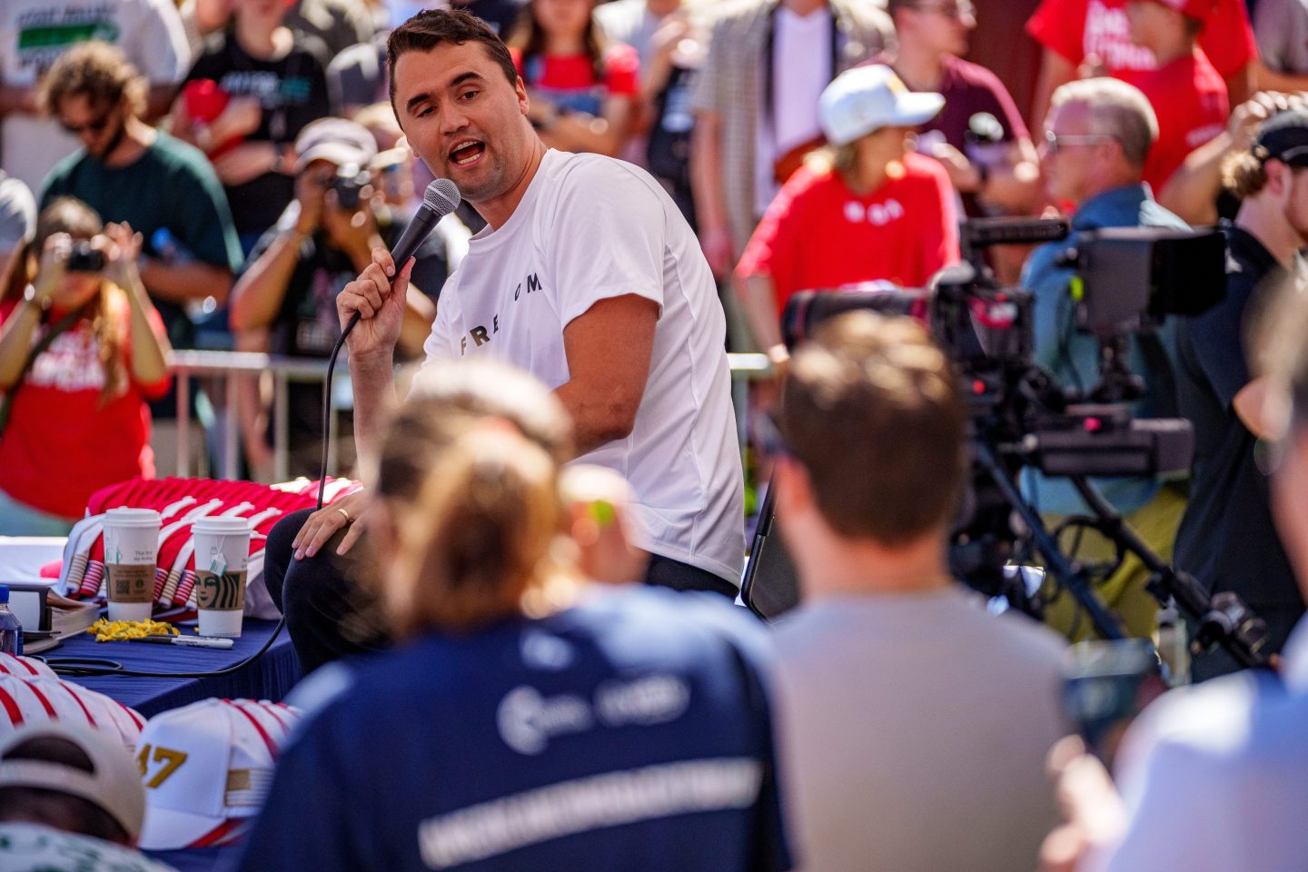 Charlie Kirk, surrounded by a crowd, speaks at Utah Valley University on September 10. He is sitting on the same chair where he was shot later.