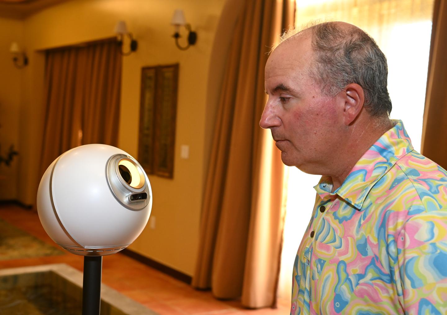 Wedbush Securities analyst Dan Ives stares into an orb, a device that scans human eyeballs and gives them Worldcoin in return.