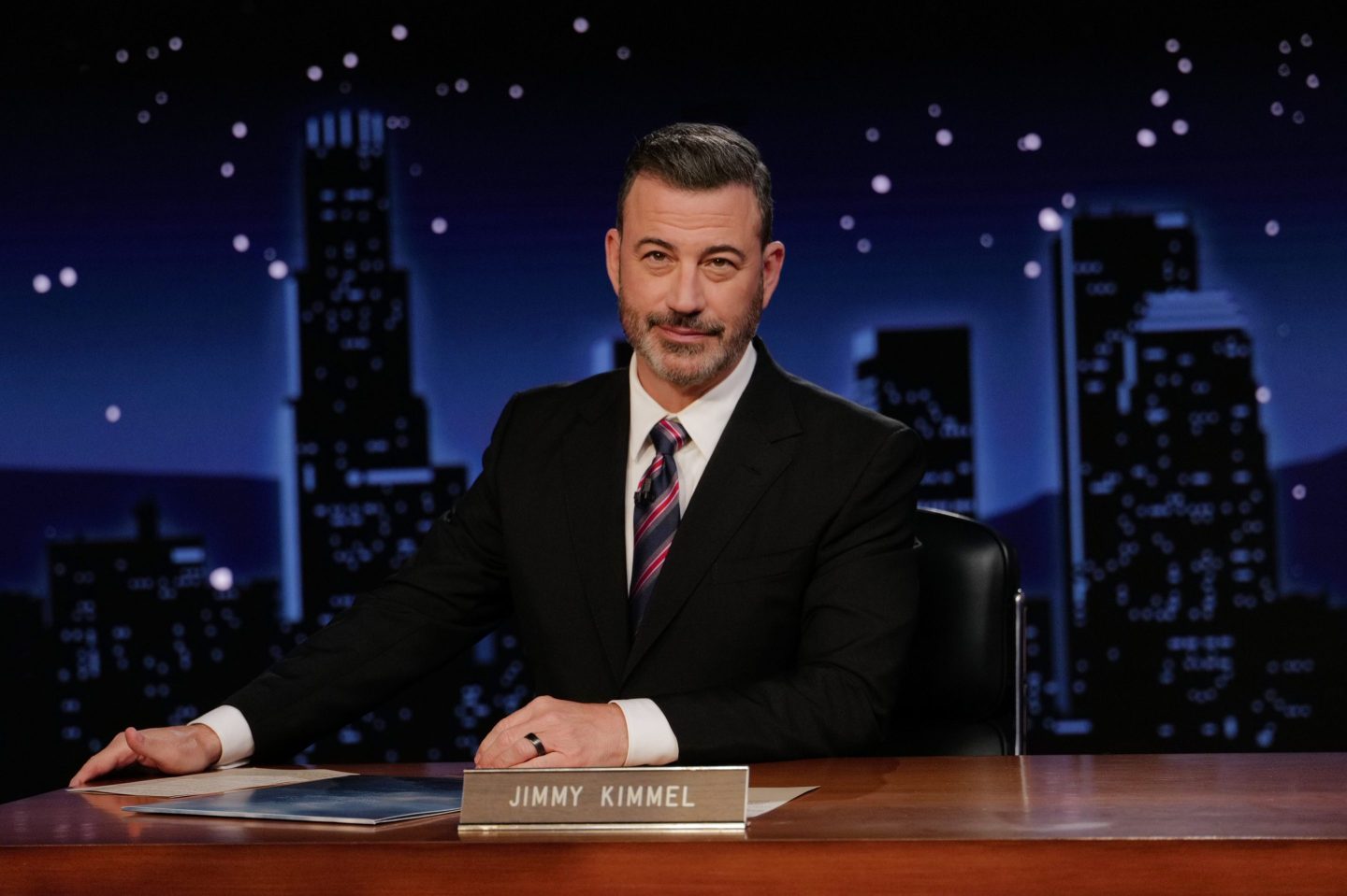 Jimmy Kimmel sits at his desk