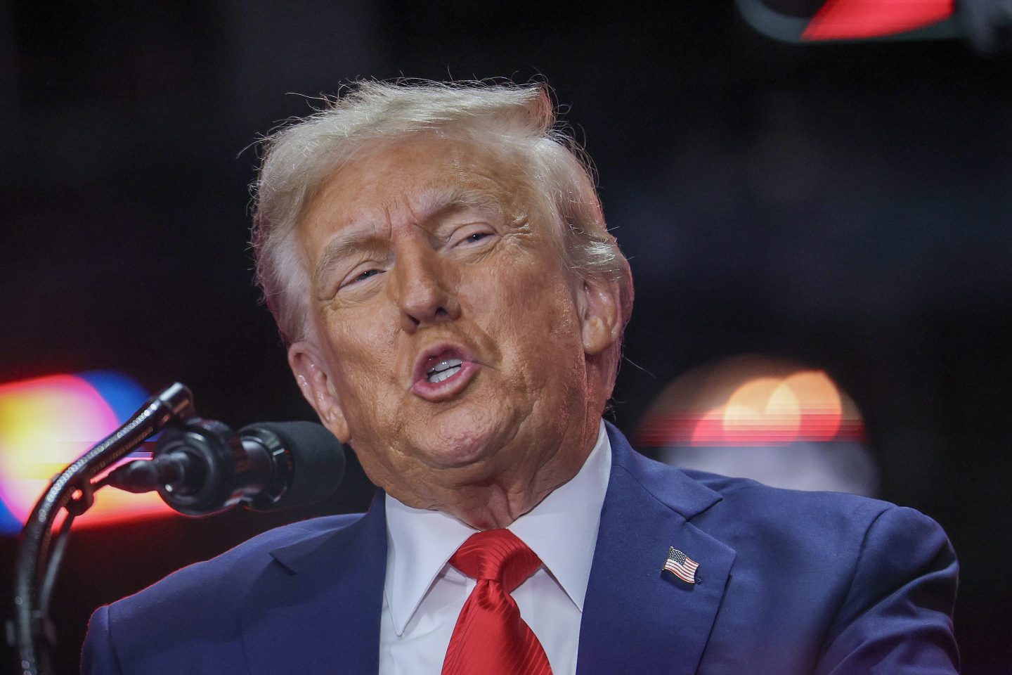 Donald Trump speaks into a microphone.