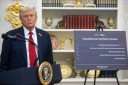 US President Donald Trump near a sign on lowering drug prices in the Oval Office of the White House in Washington, DC, US.