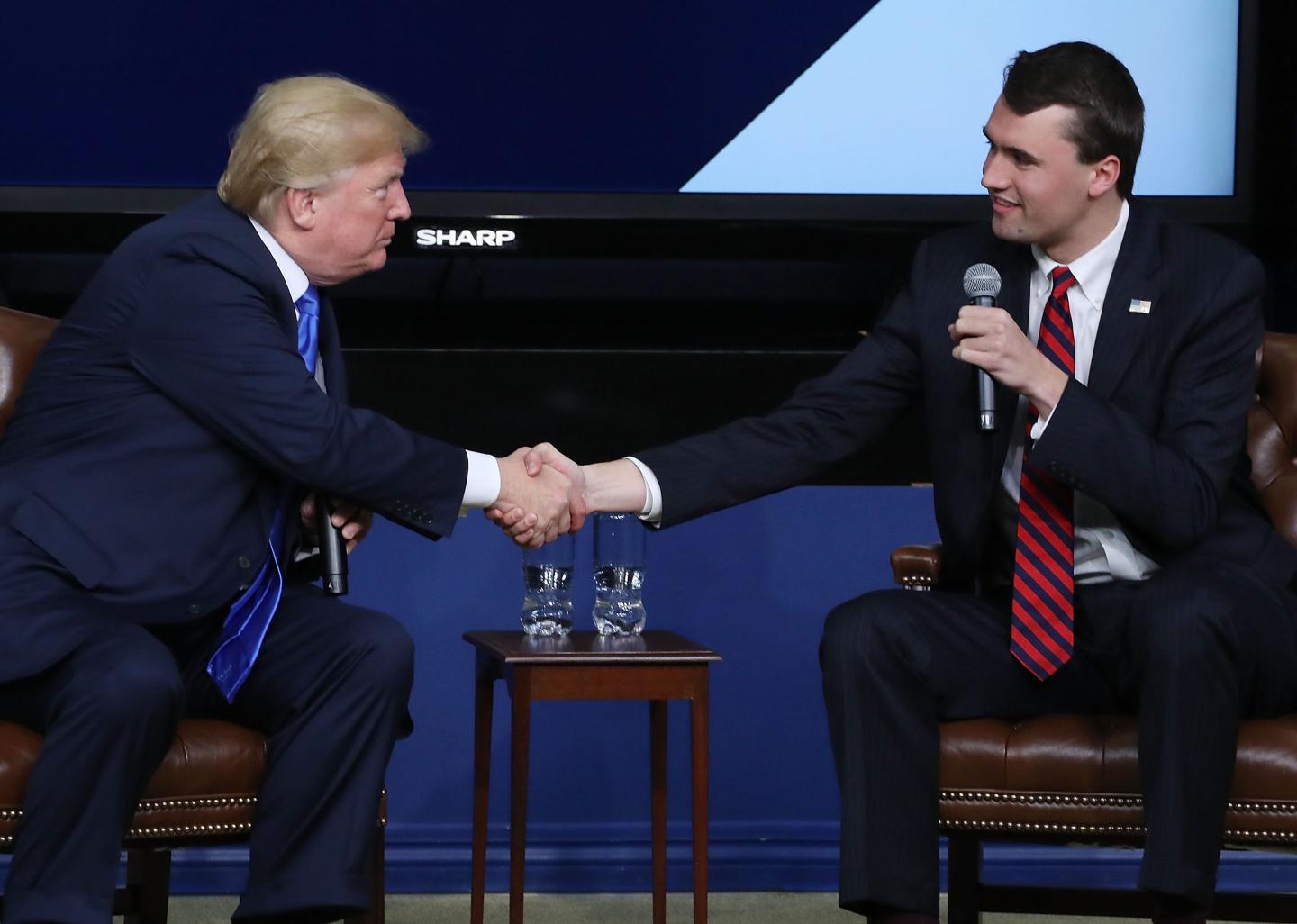 U.S. President Donald Trump shakes hands with conservative activist Charlie Kirk at a forum dubbed the Generation Next Summit at the White House on March 22, 2018 in Washington, DC.