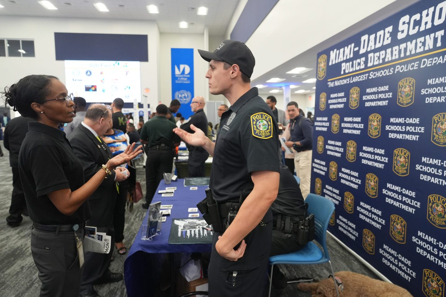 A recruiter with the Miami Dade School Police Dept. talks to a a job seeker during a job fair in Miami on Oct. 1.