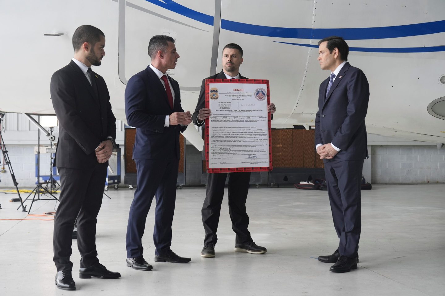 U.S. Secretary of State Marco Rubio, right, listens to Edwin F. Lopez, the attaché for DHS Homeland Security Investigations, second from left, next to the Venezuelan government airplane that Rubio announced is being seized by the U.S. during a news conference at La Isabela International Airport in Santo Domingo, Dominican Republic, Feb. 6, 2025.