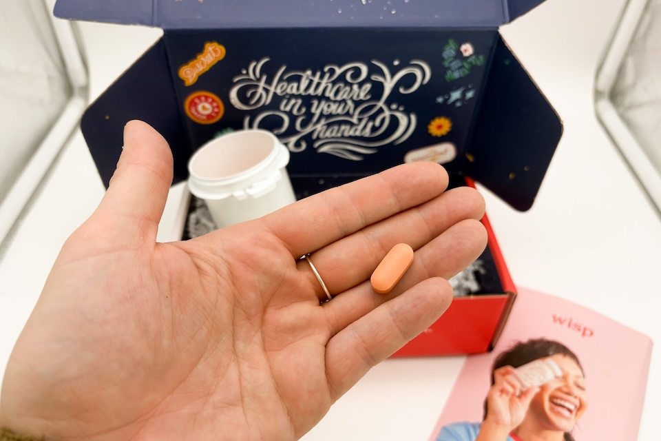 An open palm holding a Wisp Prenatal Vitamin.