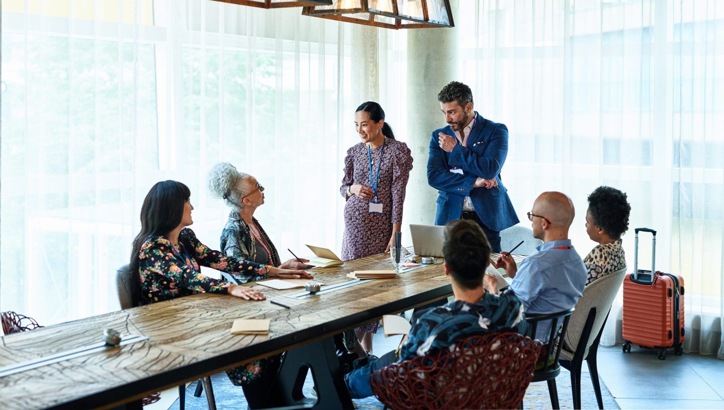 Global business meeting in conference venue, luggage in the background