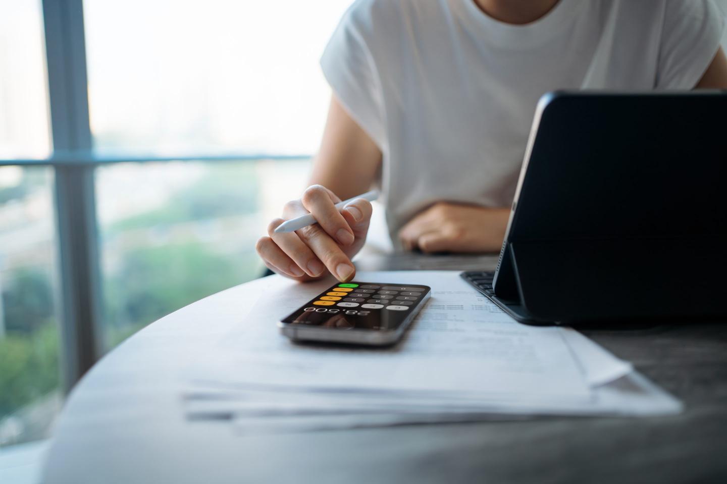 A person doing calculations and filling out forms.
