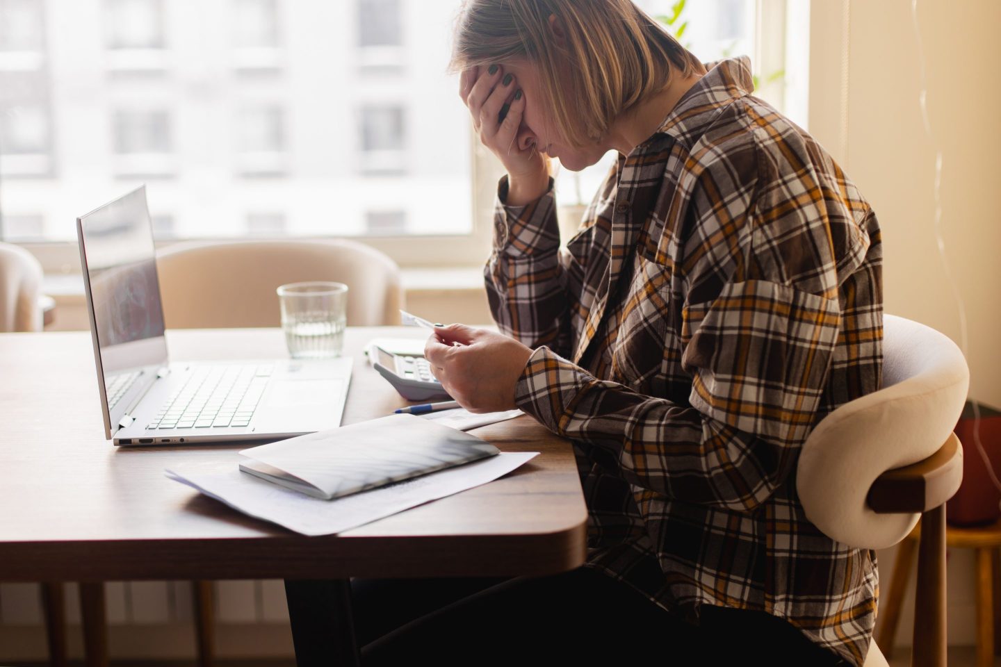 Woman sad at desk doing bills