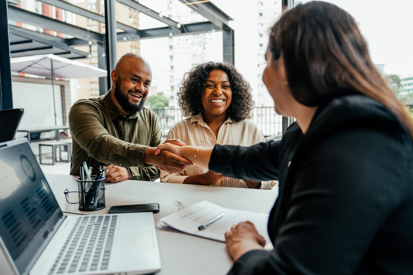 A couple meeting with someone at a bank.