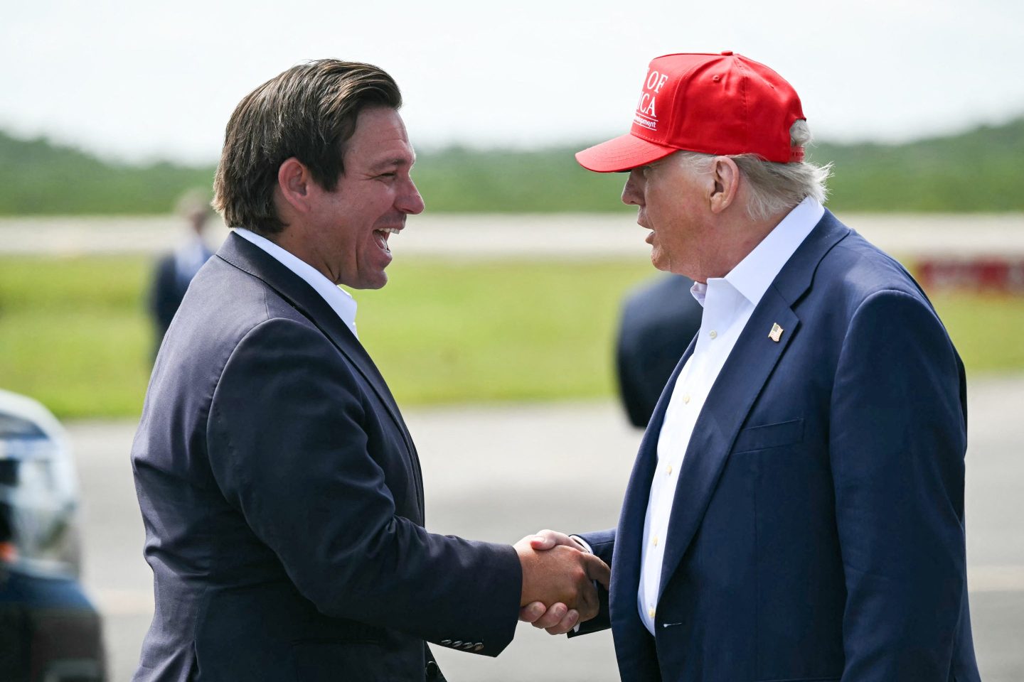 Florida Governor Ron DeSantis shakes hands with US President Donald Trump upon Trump's arrival at Dade-Collier Training and Transition Airport in Ochopee, Florida, on July 1, 2025.