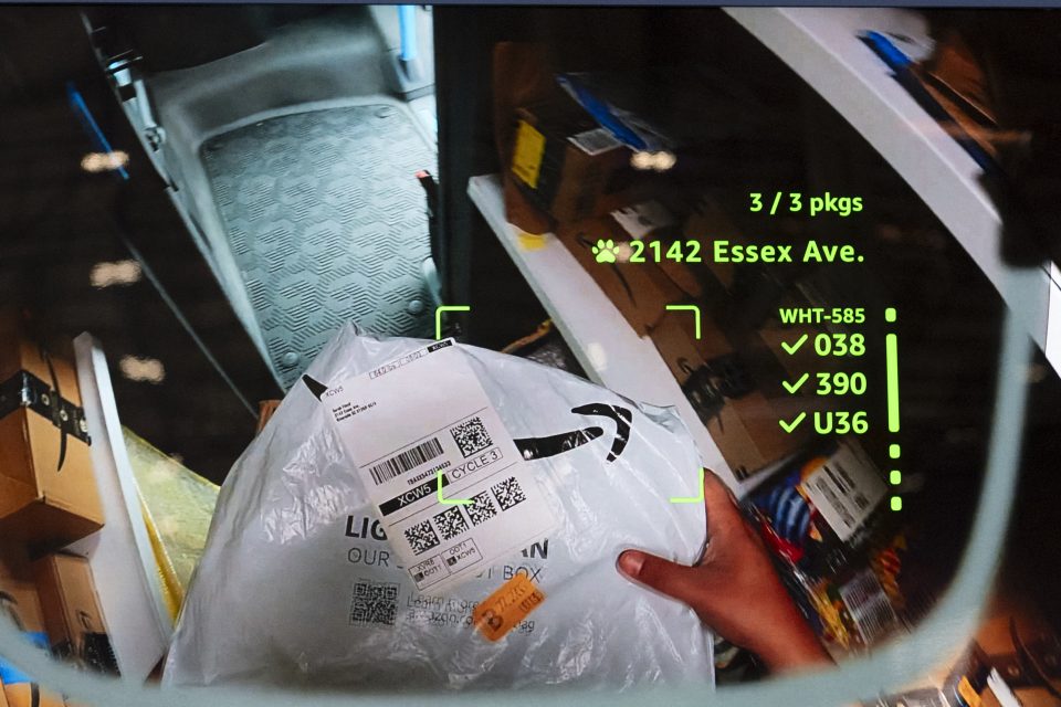 A display screen of a driver looking down at a package in their hands, with green text overlaying the display.