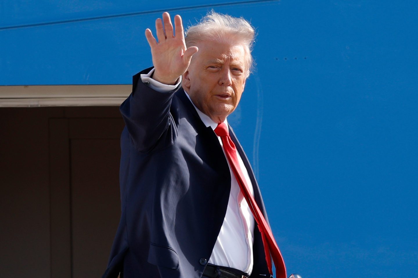 President Donald Trump waves from the stairs of Air Force One as he boards upon his arrival at Joint Base Andrews, Md., Friday.