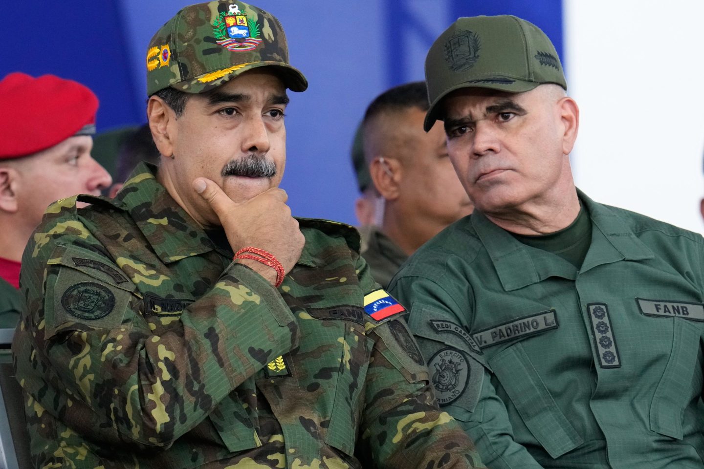Venezuelan President Nicolas Maduro, left, listens to Defense Minister Vladimir Padrino Lopez during a government-organized civic-military march in Caracas, Venezuela, Tuesday, Nov. 25, 2025.