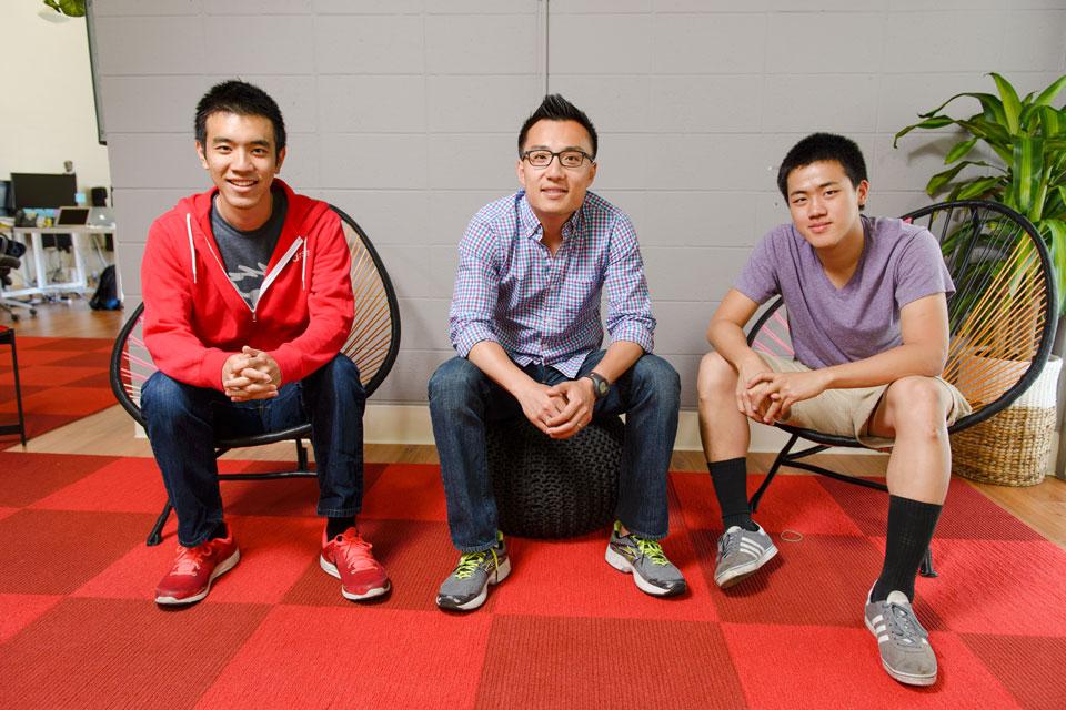 Three men sit alongside each other in chairs.