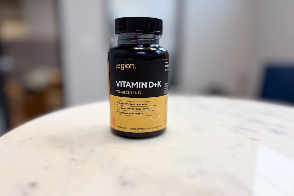 A bottle of Legion Vitamin D+K sitting on a countertop.