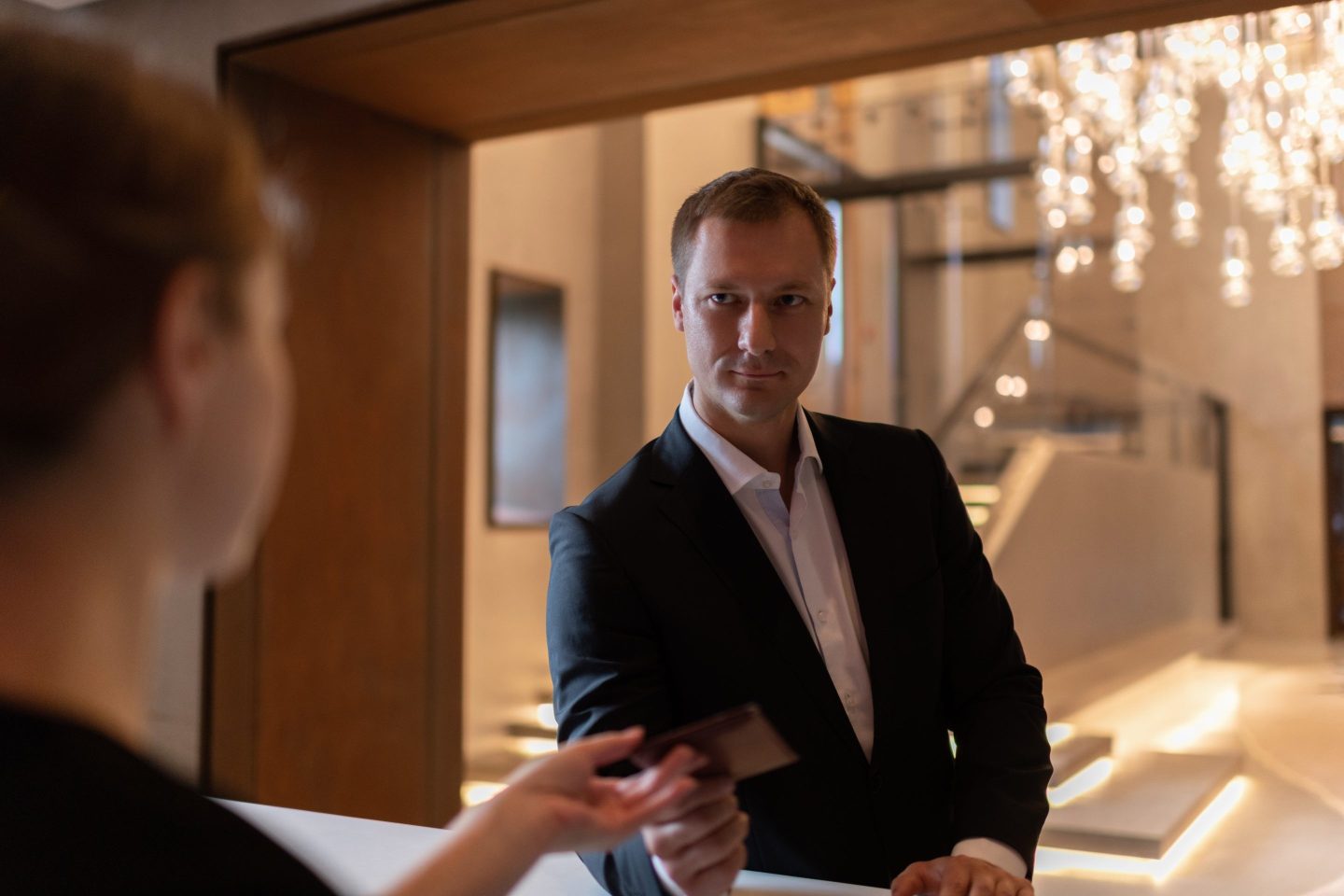 A man receives his hotel room key from the front desk