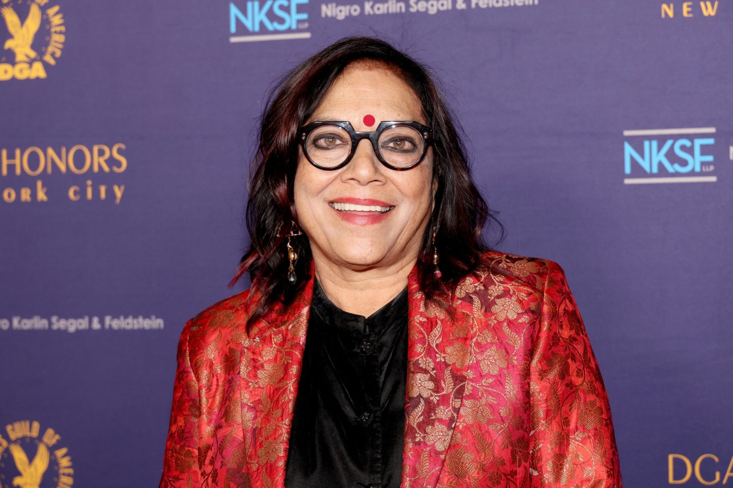 Mira Nair, Zohran Mamdani's mother, smiles on the red carpet