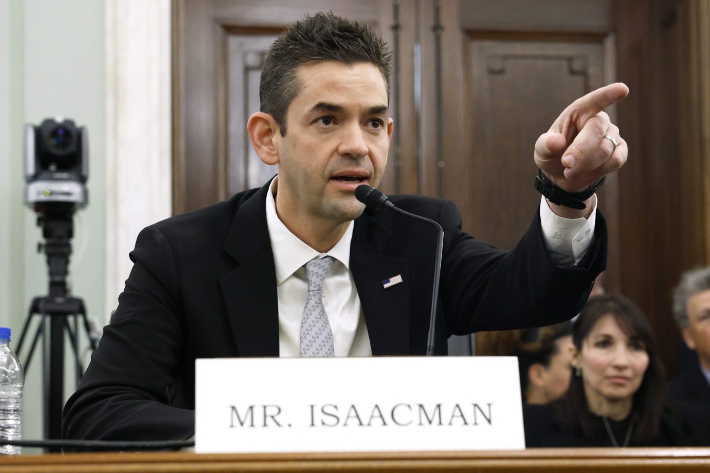 Jared Isaacman pointing, wearing a suit while testifies in the U.S. Senate