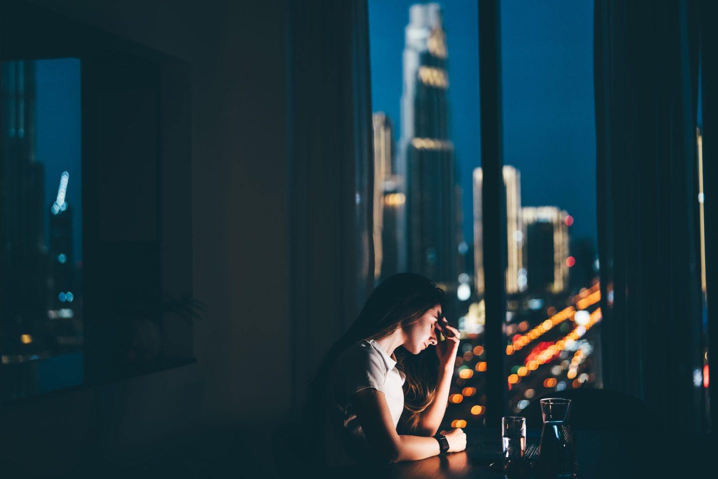 Sad freelancer woman working on laptop in the evening