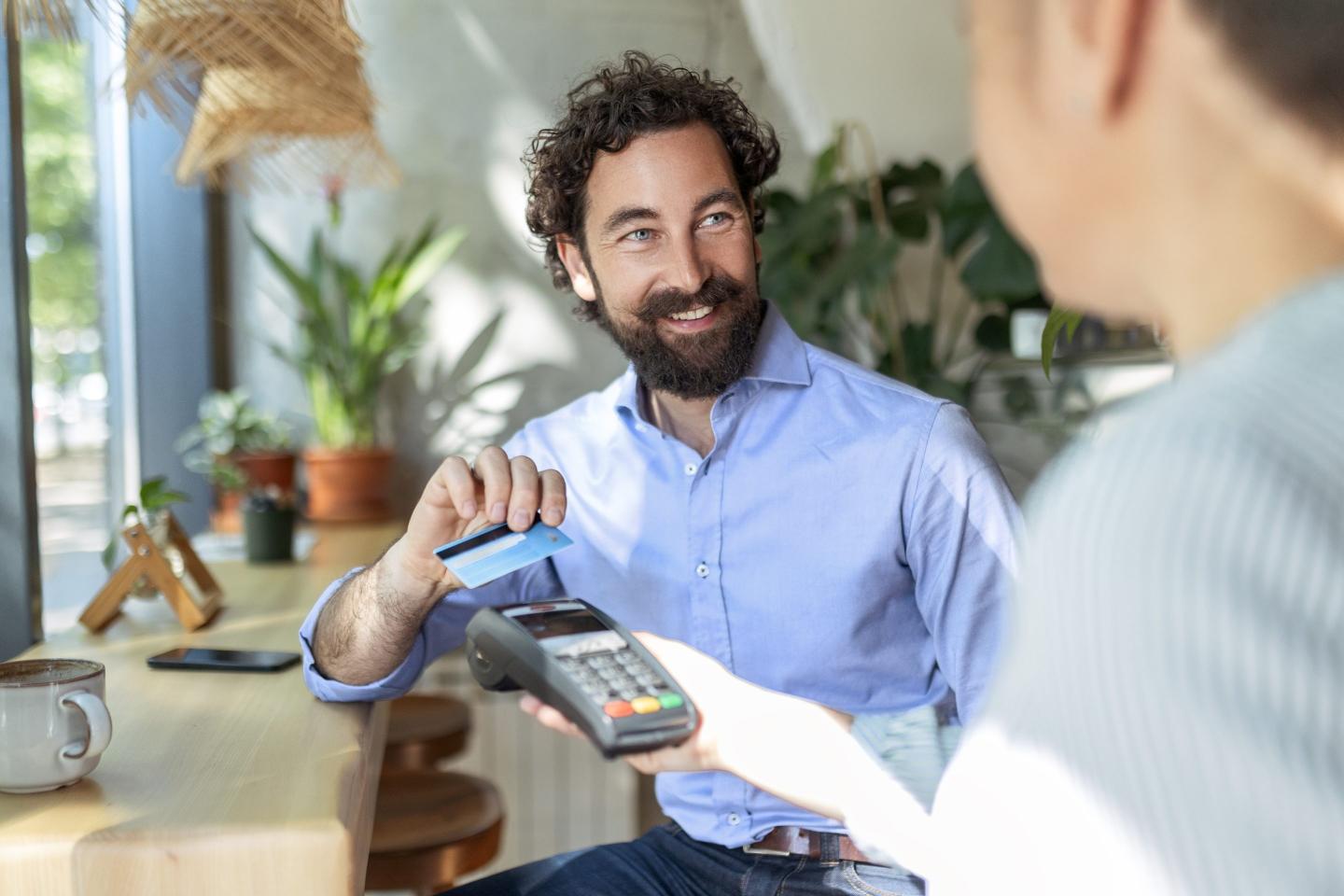 Man tapping to pay a credit card on a terminal