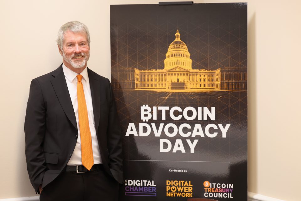 Michael Saylor next to a poster that says "Bitcoin Advocacy Day."