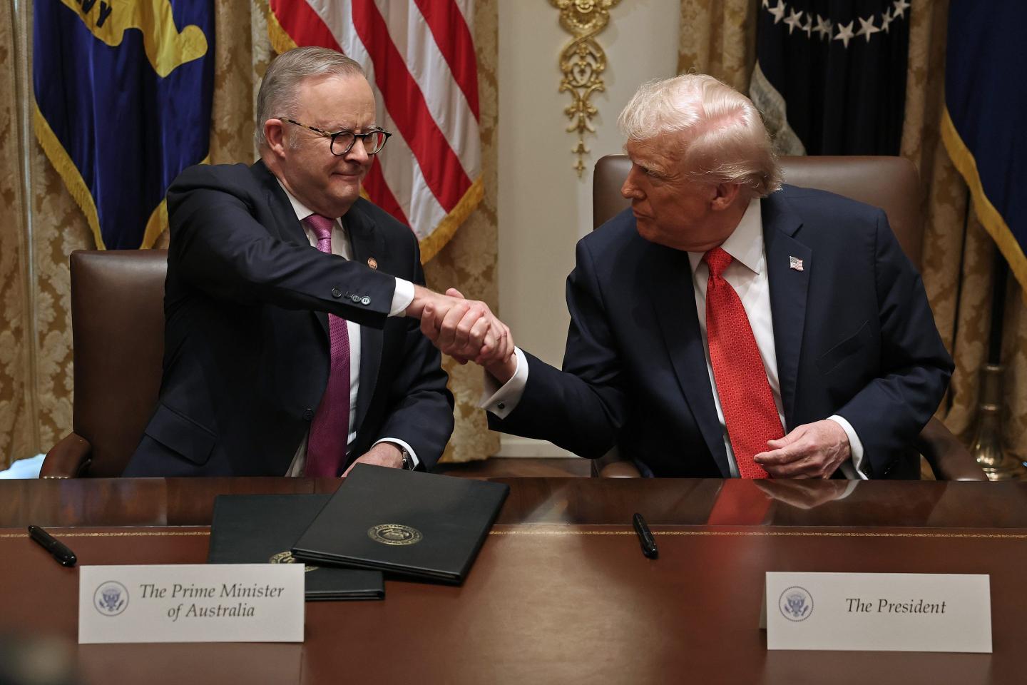 Prime Minister of Australia Anthony Albanese (L) and U.S. President Donald Trump shake hands after signing a $8.5 billion rare earth minerals agreement during a bilateral meeting in the Cabinet Room of the White House on October 20, 2025 in Washington, DC.