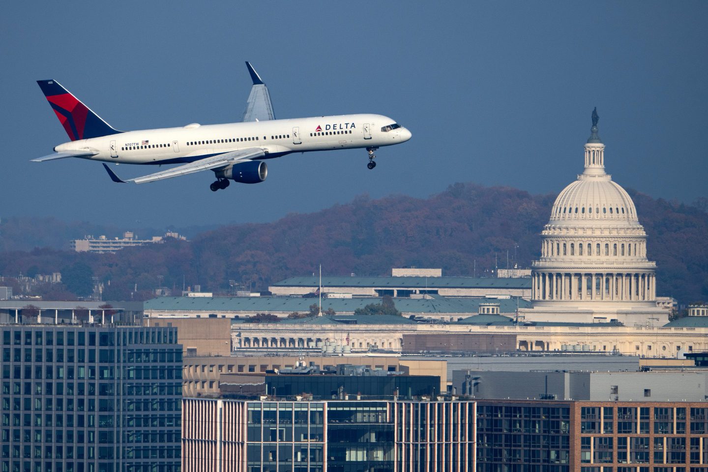 A Delta Airlines Boeing 757-200 plane passes by the U.S. Capitol dome in Washington as it comes in for a landing at Ronald Reagan Washington National Airport on Sunday, November 9, 2025.