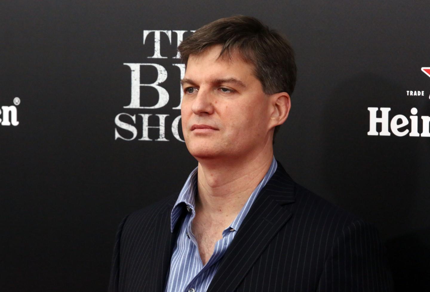 Michael Burry stands in front of a dark background with "The Big Short" printed on it.
