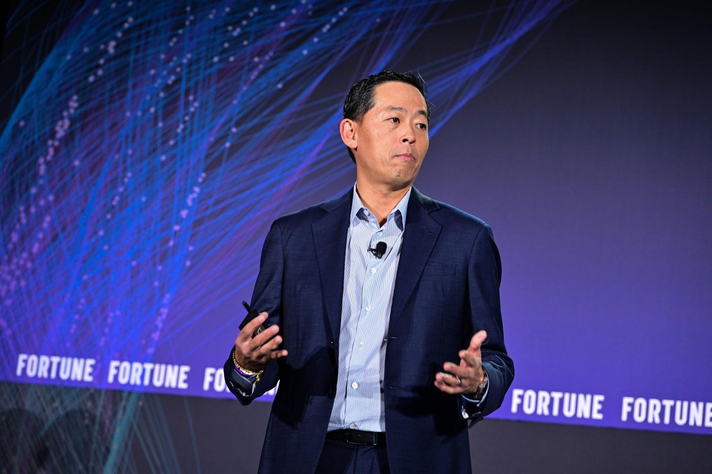 David Ko stands in front of a blue and purple "Fortune" background.