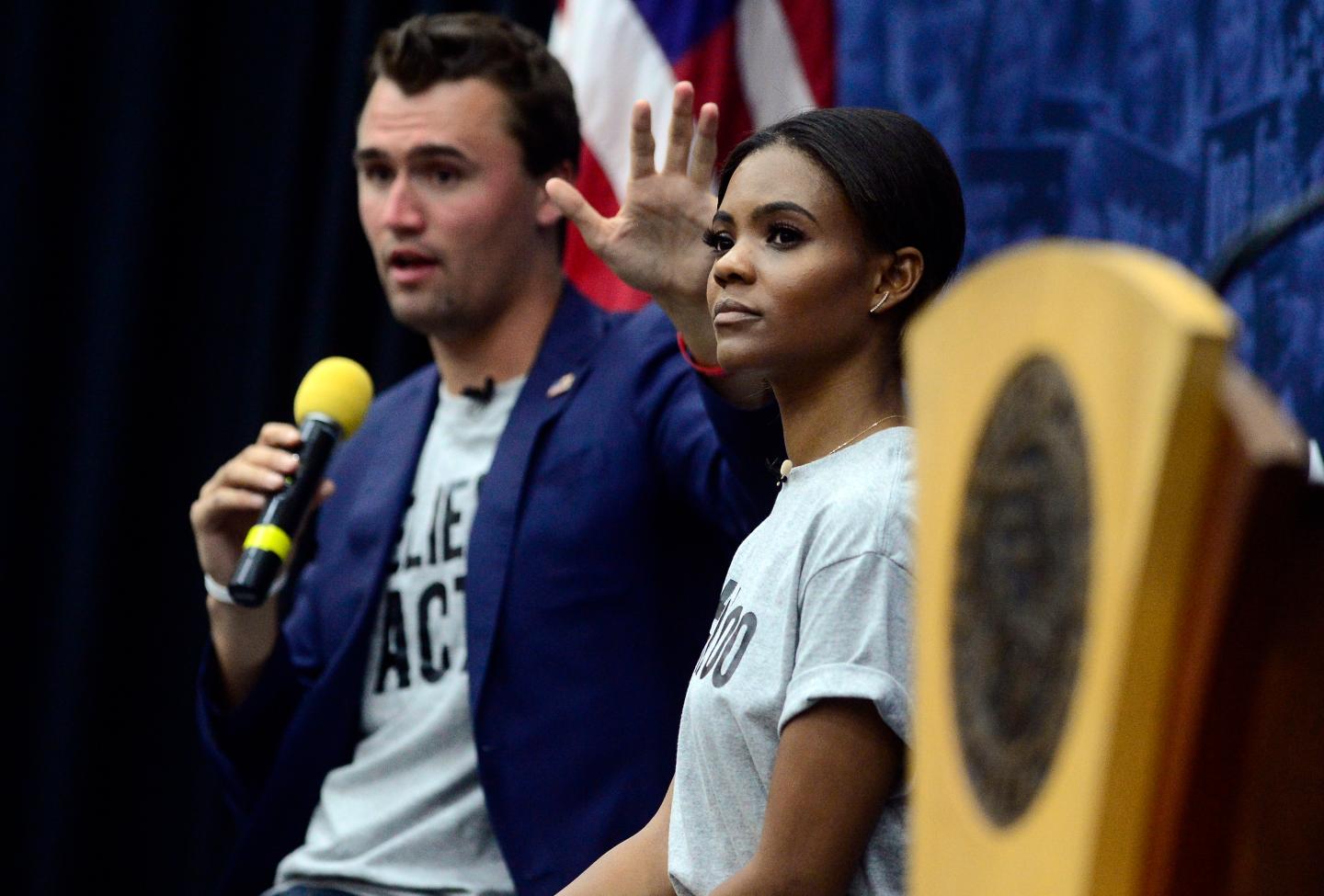 Charlie Kirk speaks into a mic next to Candace Owens